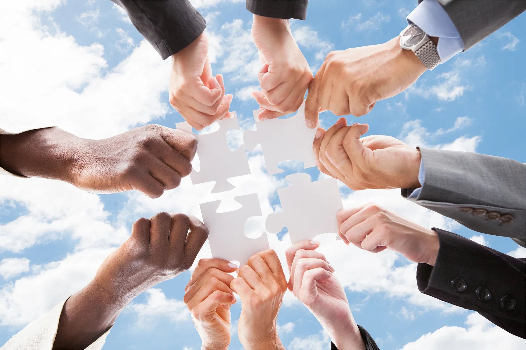 Hands fitting pieces of a puzzle together